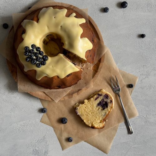Ein Stück Gugelhupf mit Heidelbeeren und weiße Schokolade Glasur